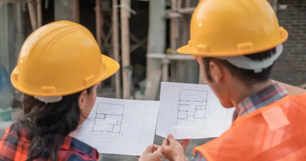 Two general contractors reviewing blueprints at a residential construction site in Boise